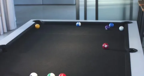 Striking white cuffed hand hitting cue ball on pool table at home, aiming to Stock Footage 338064055