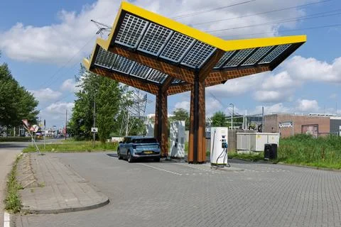 A striking yellow solar tree structure provides an EV charging station in Nie Stock Photos