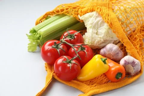 String bag with different vegetables on light grey background, closeup Foto stock