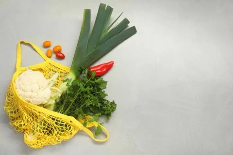 String bag with fresh vegetables on gray background, flat lay. Space for text Stock Photos