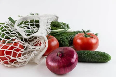 String bag with vegetables. Tomatoes, onions, labeling, potatoes, cucumbers and Stock Photos