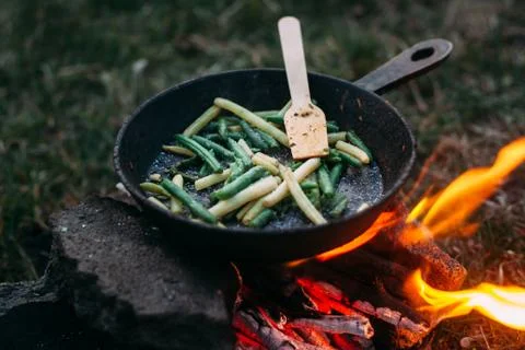 String beans in a pan. Cooking vegetables on an open fire. Food on a camping  Stock Photos