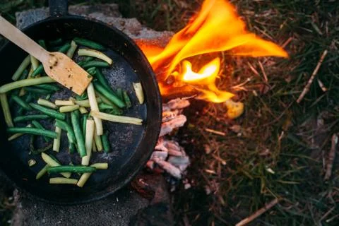 String beans in a pan. Cooking vegetables on an open fire. Food on a camping  Stock Photos