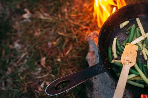 String beans in a pan. Cooking vegetables on an open fire. Food on a camping  Stock Photos