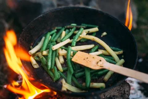 String beans in a pan. Cooking vegetables on an open fire. Food on a camping  Stock Photos