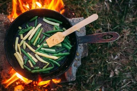 String beans in a pan. Cooking vegetables on an open fire. Food on a camping  Stock Photos