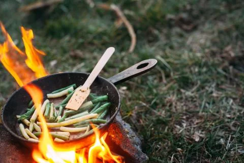 String beans in a pan. Cooking vegetables on an open fire. Food on a camping  Stock Photos