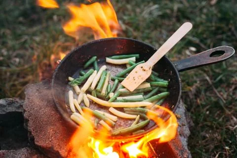 String beans in a pan. Cooking vegetables on an open fire. Food on a camping  Stock Photos