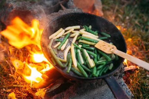 String beans in a pan. Cooking vegetables on an open fire. Food on a camping  Stock Photos