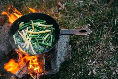 String beans in a pan. Cooking vegetables on an open fire. Food on a camping  Stock Photos