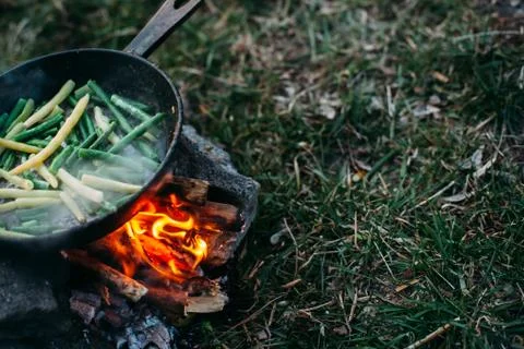 String beans in a pan. Cooking vegetables on an open fire. Food on a camping  Stock Photos
