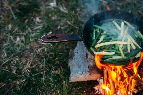 String beans in a pan. Cooking vegetables on an open fire. Food on a camping  Stock Photos