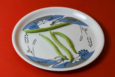 String beans on plate close on isolated red background Stock Photos