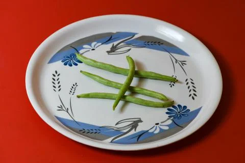 String beans on plate close on isolated red background Stock Photos