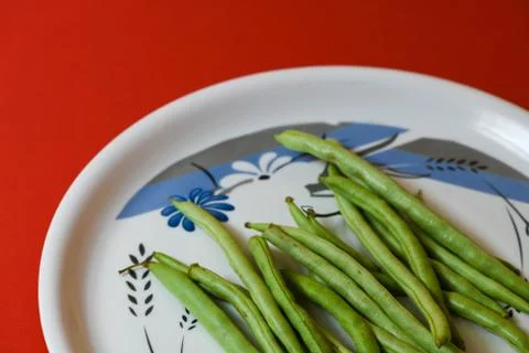 String beans on plate close on isolated red background Stock Photos