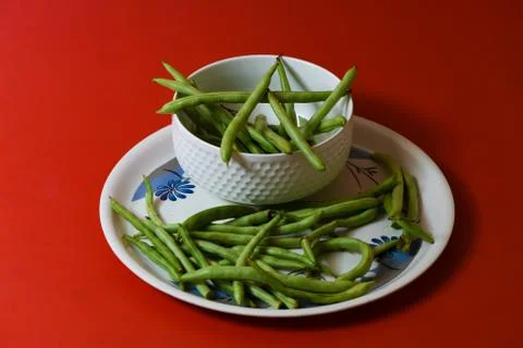 String beans on plate close on isolated red background Stock-Fotos