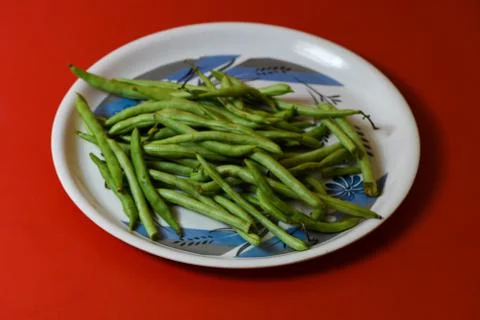 String beans on plate close on isolated red background Stock Photos