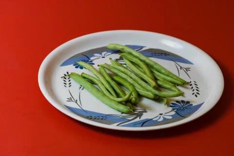 String beans on plate close on isolated red background Stock Photos