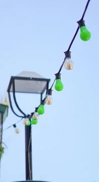 String of decorative green bulbs hanging on a lamp post Stock Photos