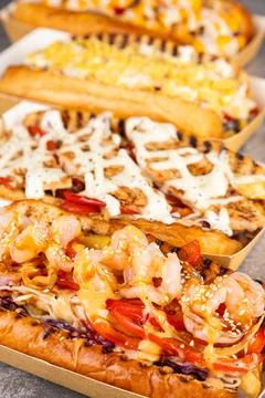 A string of delicious hot dogs from different recipes in paper gondolas Stock Photos