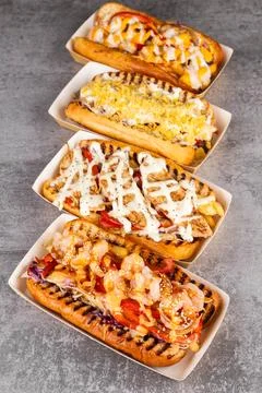 A string of delicious hot dogs from different recipes in paper gondolas Stock Photos