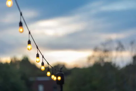 String of glowing edison light bulbs creates festive outdoor vibe Foto stock