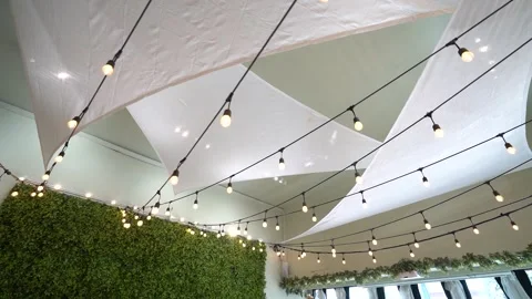String lights and white fabric sails below an event hall ceiling Stock Footage 345552752
