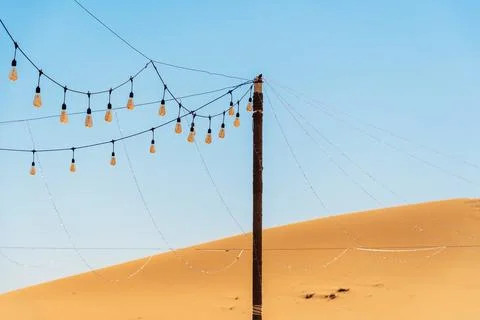String lights are strung across a pole in the desert Stock Photos