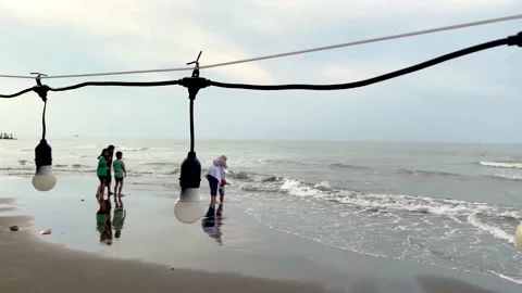 String of lights on the beach with people in the background Stock Footage 234102878