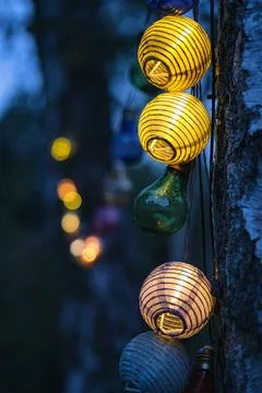 String of lights in bulb shape. Garden party or relaxing evening outdoors.... Stock Photos