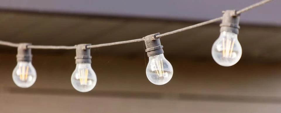 A string of lights with four bulbs hanging from a wire Foto stock