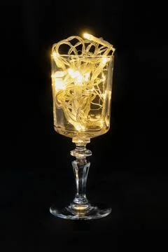String lights glowing warmly in vine glass Stock Photos