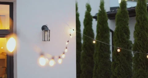 String lights hanging on line on outside house in backyard. Garden decoration Video stock 316144365