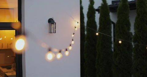 String lights hanging on line on outside house in backyard. Garden decoration Stock Footage 316144711