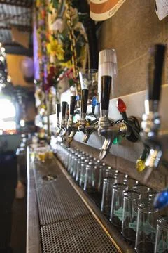 String lights hanging over beer taps in brewery Stock Photos