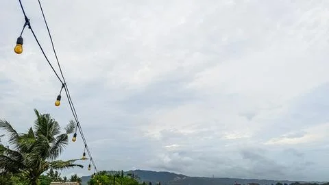 A string of lights hanging from a power line Stock Photos