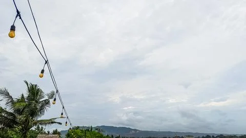 A string of lights hanging from a power line Stock Photos