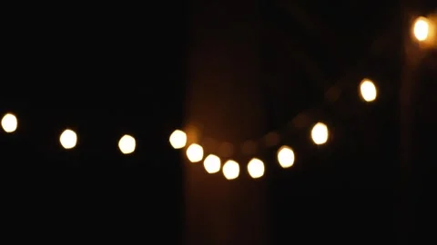 String lights at night, blurred bulbs transitioning into sharp focus Stock Footage 315418961