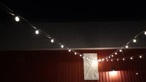 String lights on red barn at night Stock Footage 338035248
