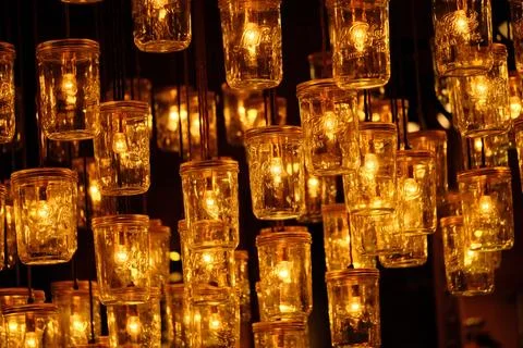 A string of lit candle lights hanging from a ceiling with a pattern Stock Photos