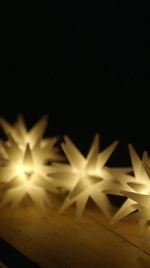 String of many magic star lights on a wooden table illuminate the darkness Video stock 292673639