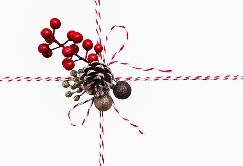 String or tied in bow with branches red berries and pine cones Stock Photos