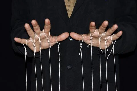 String pulling puppeteer studio photography with black background Foto stock