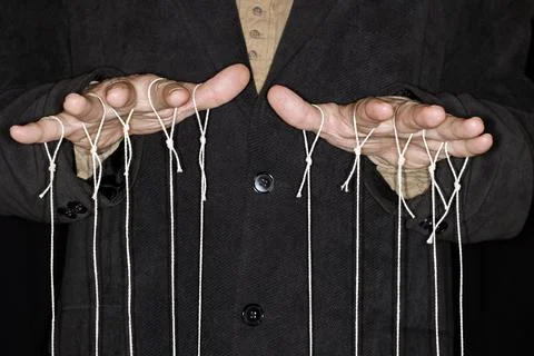 String pulling puppeteer studio photography with black background 写真素材