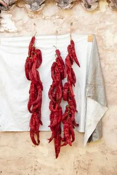 A string of red peppers drying in the sun Stock Photos