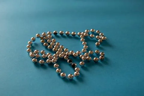 String of silver gray beads on blue background Stock Photos