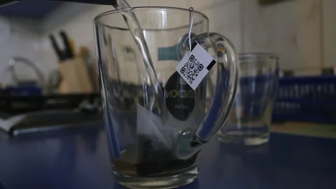 The string from the tea bag falls into the mug Stock Footage 156438467