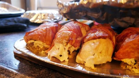 String tied turkey stuffing bacon wrapped parcels on aluminium serving Stock Footage 167867989