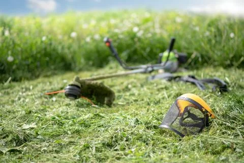 String trimmer and protective face mask on mown grass Fotos Stock