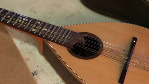A stringed Asian instrument is lying on the workshop table. Video stock 320386972
